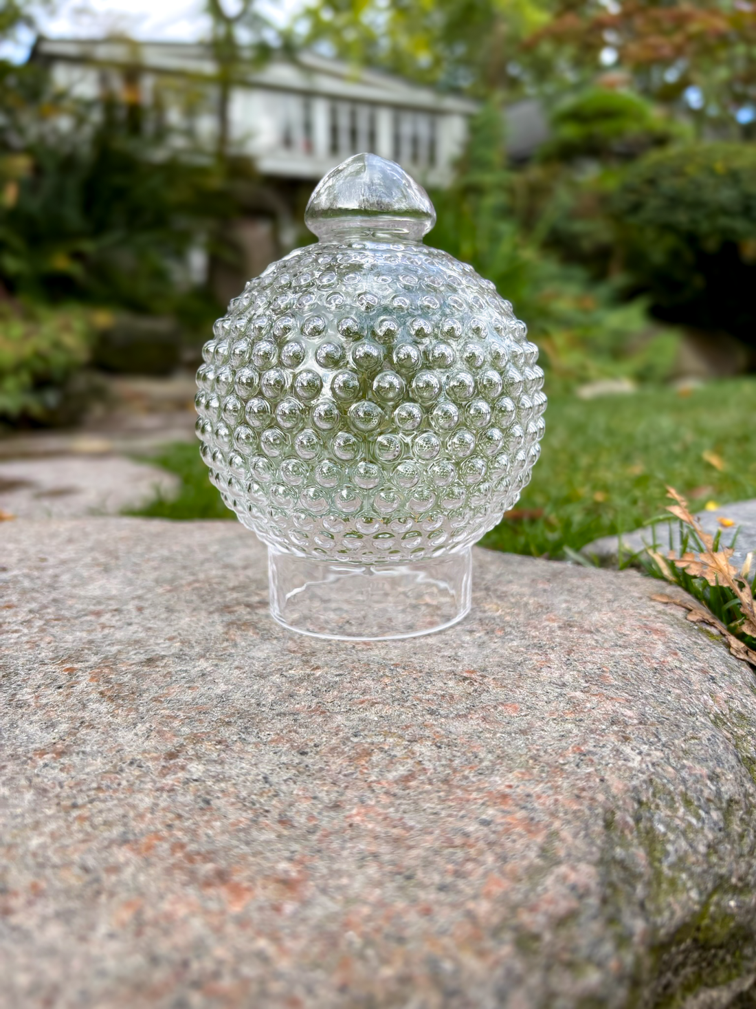 Klar Tivoli glaskuppel inspireret af Michael Bangs ikoniske lampedesign fra 1967, udført i glas med karakteristisk knopstruktur og plads til fyrfadslys.