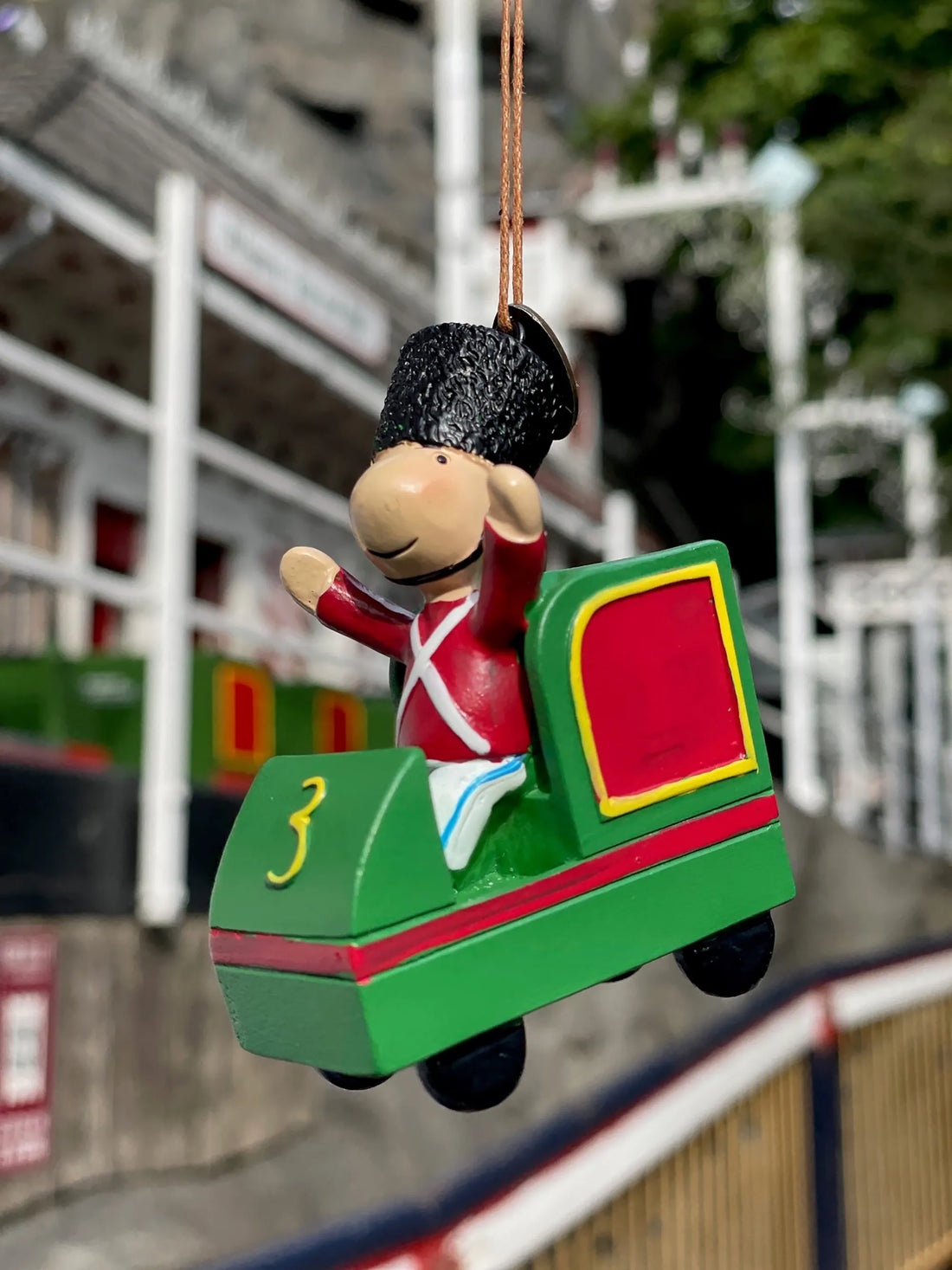 Håndmalet ophæng fra KIDS by FRIIS inspireret af Tivolis ikoniske Rutschebane med Tivoli Garder i grøn rutsjebanevogn.