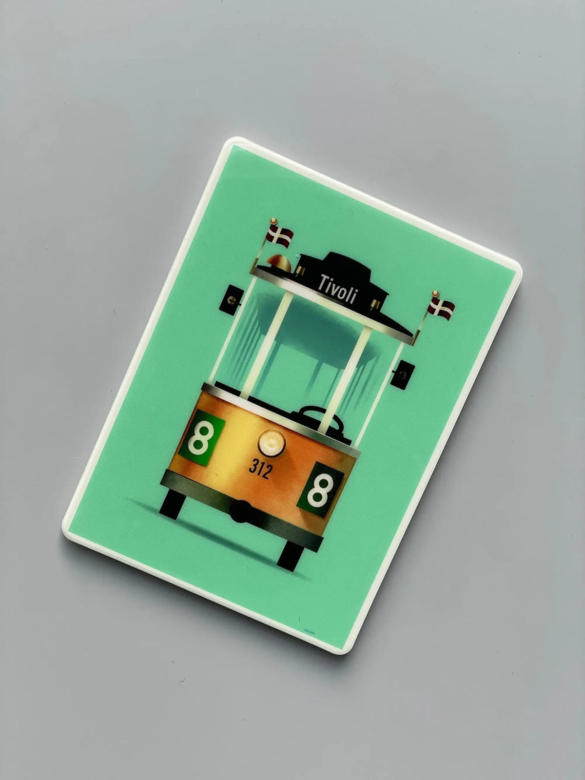 Linie 8 magnet med Mads Bergs illustration af Tivolis ikoniske sporvogn i karakteristisk retrodesign på turkis baggrund.