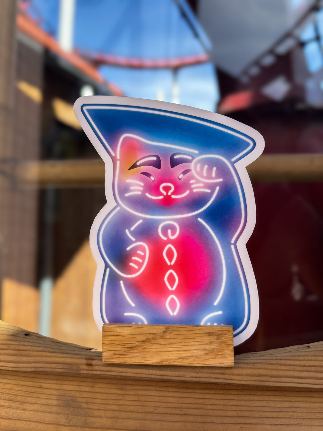 Little Tivoli Hikari Pjerrot Katten-postkort med neoninspireret motiv af en kat i blå og pink nuancer med Pjerrots karakteristiske hat, inspireret af Tivolis magiske Hikari-univers.