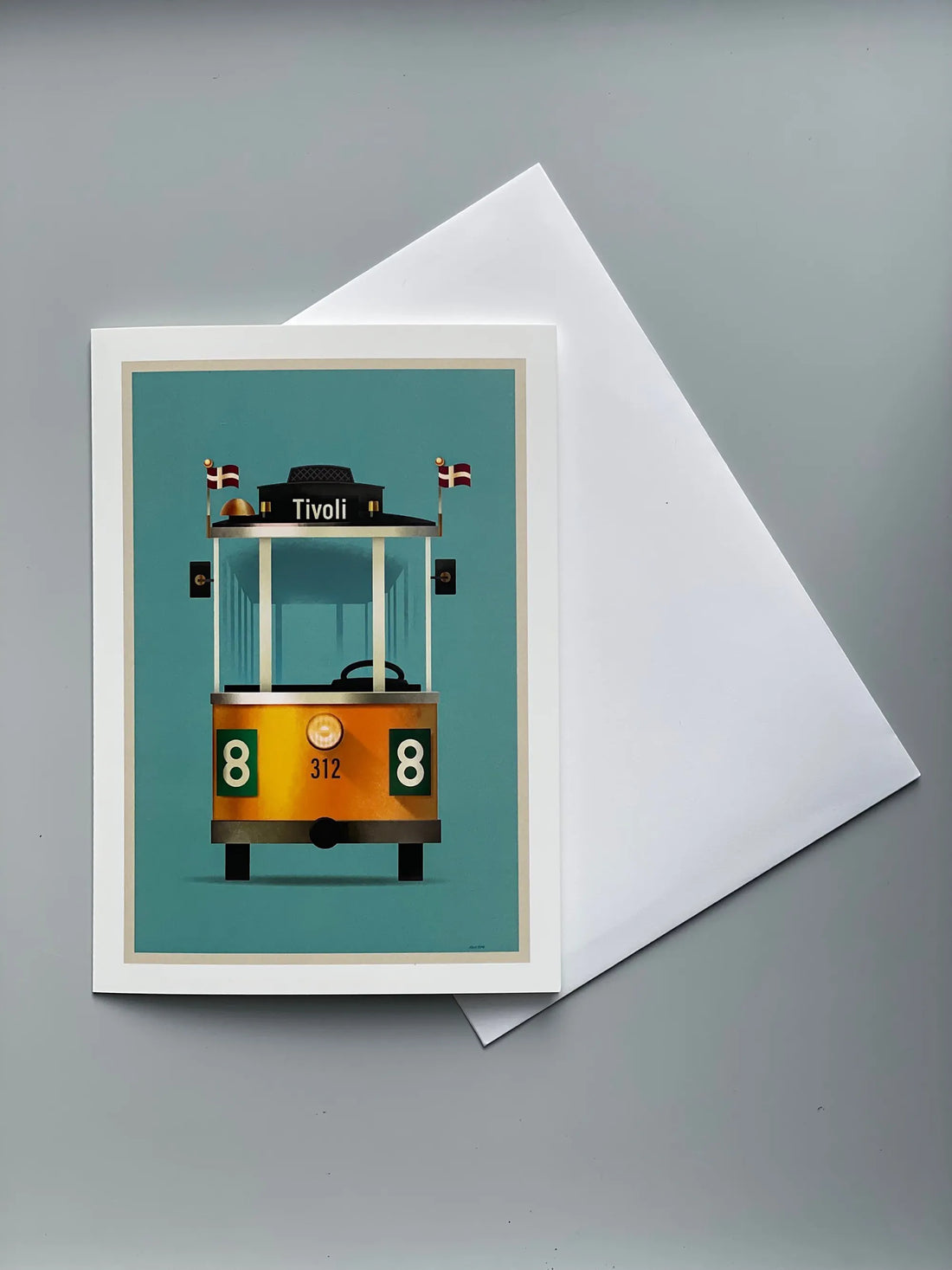 Foldekort med Mads Bergs illustration af Tivolis ikoniske Linie 8-sporvogn, fotograferet foran forlystelsen i Tivoli.