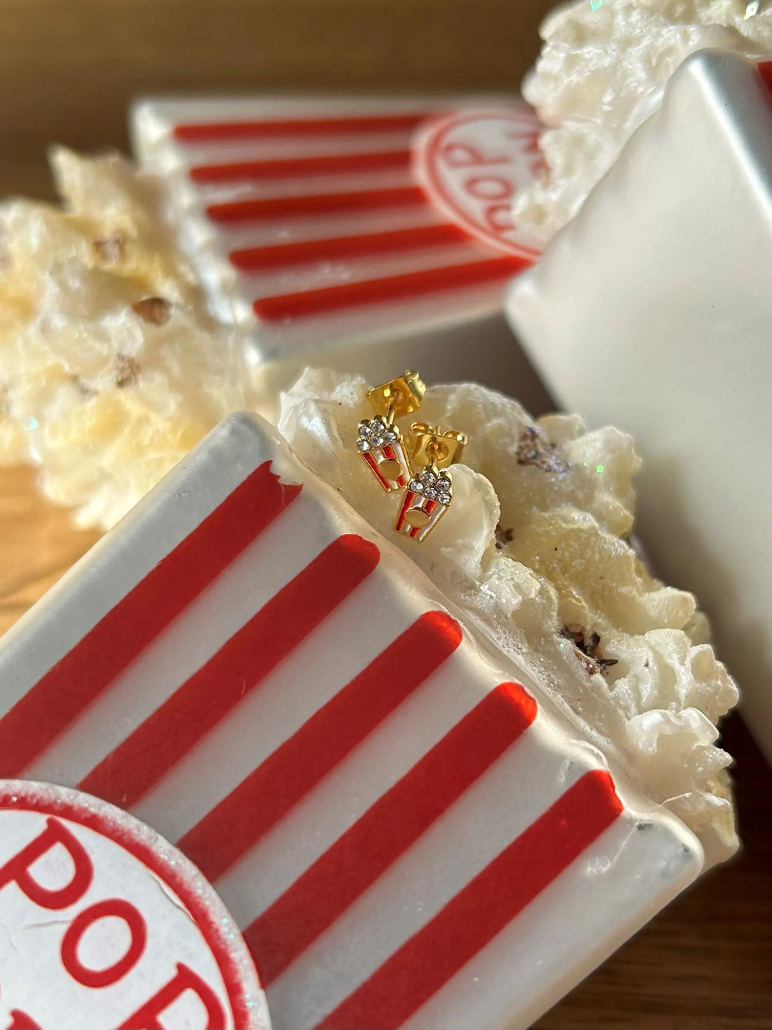 Popcorn ørestikker i forgyldt messing med røde og hvide emaljedetaljer, inspireret af Tivolis klassiske popcornbægre.