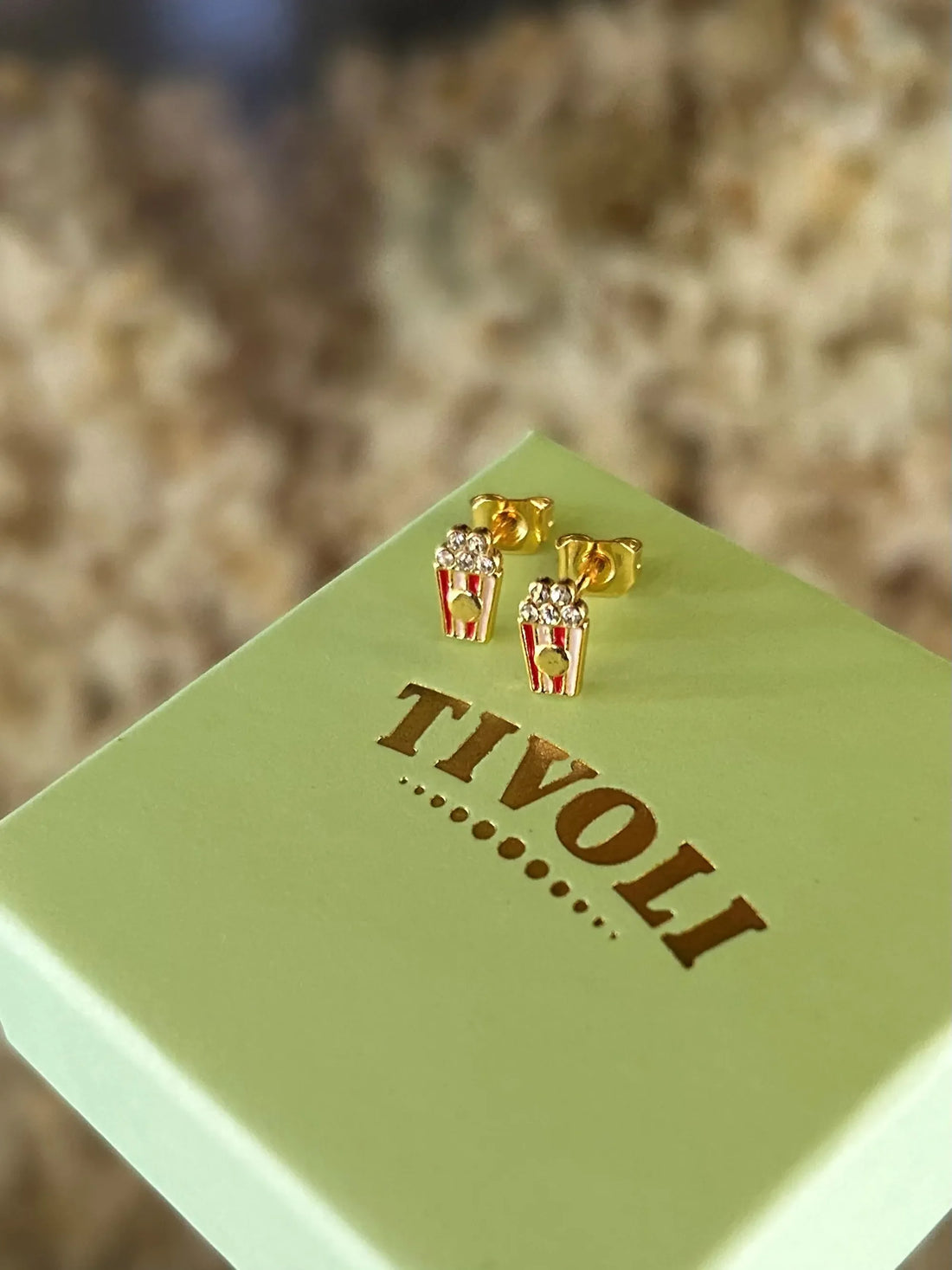 Popcorn ørestikker i forgyldt messing med røde og hvide emaljedetaljer, inspireret af Tivolis klassiske popcornbægre.