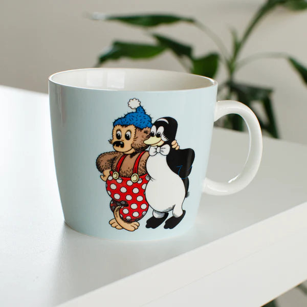 Lyseblå Rasmus Klump-kop i porcelæn med motiv af Rasmus Klump og Pingo. De to populære figurer står side om side på kruset, som er dekoreret i klassisk Rasmus Klump-stil.