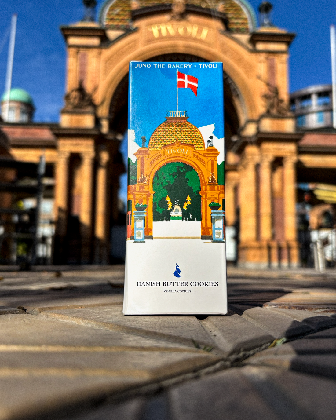 Tivoli x JUNO Bakery vanilje cookies pakke med illustration af tivolis hovedindgangen på foran hovedindgangen.