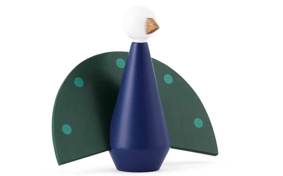 Tivoli påfugl træfigur i blå, grønne og turkise nuancer. Figuren har stiliseret påfuglekrop i blåt træ, grøn halefjer med dekorative prikker samt hvidt hoved med gyldent næb. Designet er inspireret af Tivolis ikoniske fritgående påfugle.